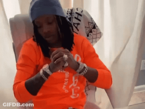 A Man Wearing An Orange Shirt That Says ' A.h. ' On It GIF