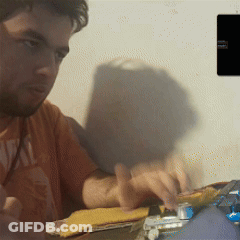A Man Wearing An Orange Shirt That Says ' Real ' On The Front GIF