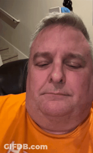 A Man Wearing An Orange Shirt With The Letter H On The Front GIF