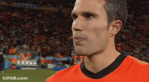 A Man Wearing An Orange Shirt With The Letter S On The Bottom Right GIF