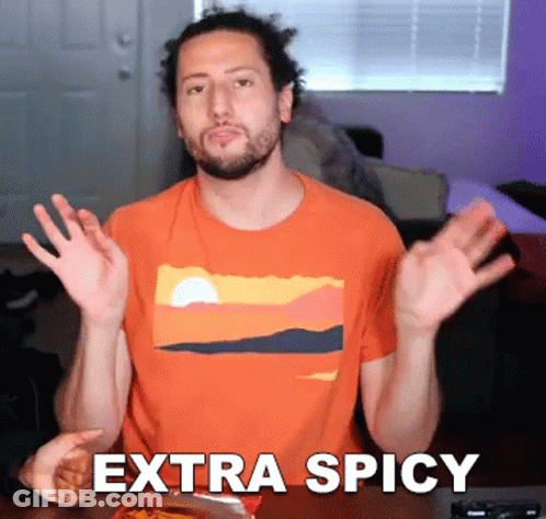 A Man Wearing An Orange Shirt With The Word Extra Spicy On It GIF