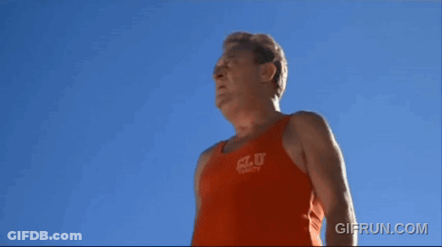 A Man Wearing An Orange Tank Top That Says C.l.u. On It GIF