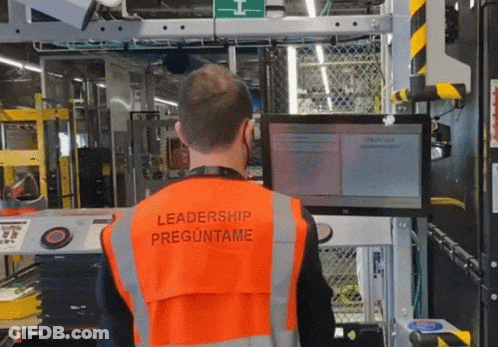 A Man Wearing An Orange Vest With Leadership Preguntame On It GIF