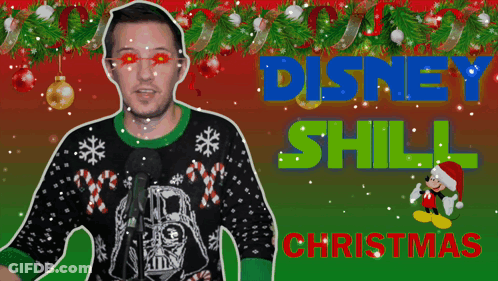 A Man Wearing An Ugly Christmas Sweater Stands In Front Of A Microphone With The Words Disney Still Christmas Behind Him GIF