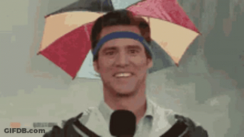 A Man Wearing An Umbrella On His Head With A Microphone GIF