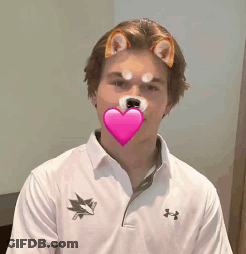 A Man Wearing An Under Armour Shirt Has A Heart In His Mouth GIF