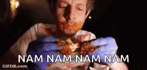 A Man Wearing Blue Gloves Is Eating A Piece Of Meat With The Words Nam Nam Nam Nam Written Below Him . GIF