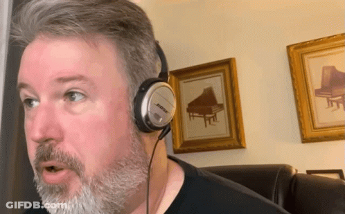 A Man Wearing Bose Headphones Is Talking GIF