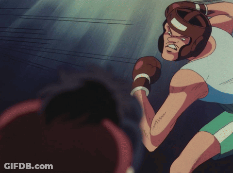 A Man Wearing Boxing Gloves And A Helmet Is Getting Ready To Throw A Punch GIF