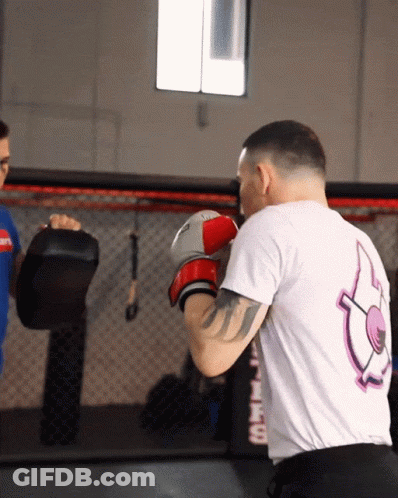 A Man Wearing Boxing Gloves And A Shirt That Says ' Fire ' On The Back Of It GIF