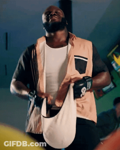 A Man Wearing Boxing Gloves And A Vest With The Letter G On The Front GIF