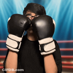 A Man Wearing Boxing Gloves Covers His Face With His Hands GIF