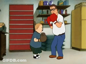 A Man Wearing Boxing Gloves Is Standing Next To A Little Boy GIF