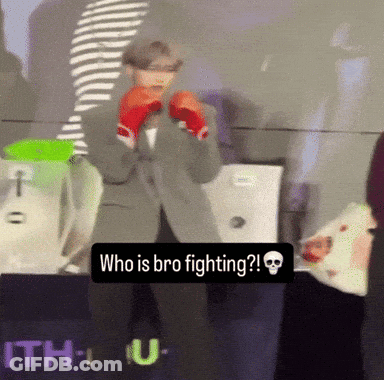A Man Wearing Boxing Gloves Stands In Front Of A Sign That Says " Who Is Bro Fighting " GIF