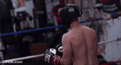 A Man Wearing Boxing Gloves That Say Nz On Them Is Standing In A Boxing Ring GIF