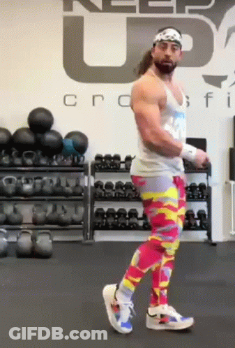 A Man Wearing Colorful Pants Is Standing In A Gym . GIF