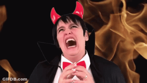 A Man Wearing Devil Horns And A Black Cape Screams GIF