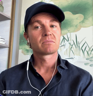 A Man Wearing Ear Buds And A Baseball Cap Looks At The Camera GIF