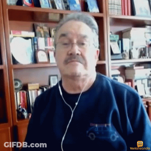 A Man Wearing Ear Buds And A Blue Shirt With A Car On It GIF