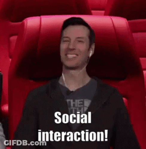 A Man Wearing Ear Buds Is Sitting In A Movie Theater And Says Social Interaction . GIF