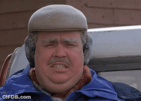 A Man Wearing Ear Muffs And A Hat Looks Angry GIF