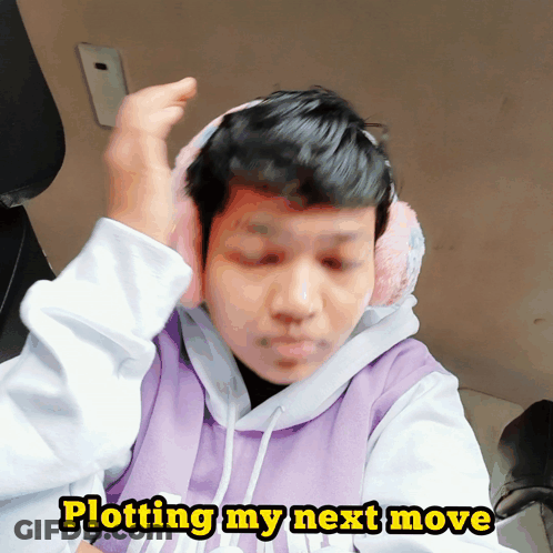 A Man Wearing Ear Muffs And A Purple Sweatshirt Says Plotting My Next Move GIF