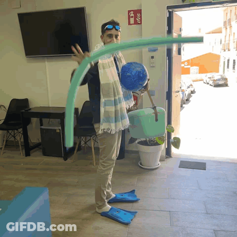 A Man Wearing Flippers Is Holding A Swimming Noodle In Front Of A Fire Extinguisher GIF