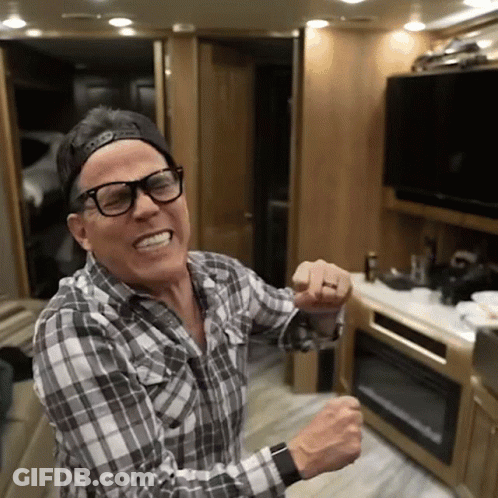 A Man Wearing Glasses And A Baseball Cap Is Dancing In A Kitchen GIF