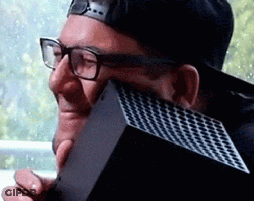 A Man Wearing Glasses And A Baseball Cap Is Holding A Xbox Box . GIF