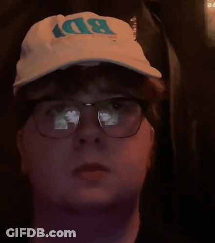 A Man Wearing Glasses And A Bd Hat GIF