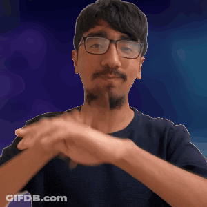 A Man Wearing Glasses And A Beard Is Making A Gesture With His Hands GIF