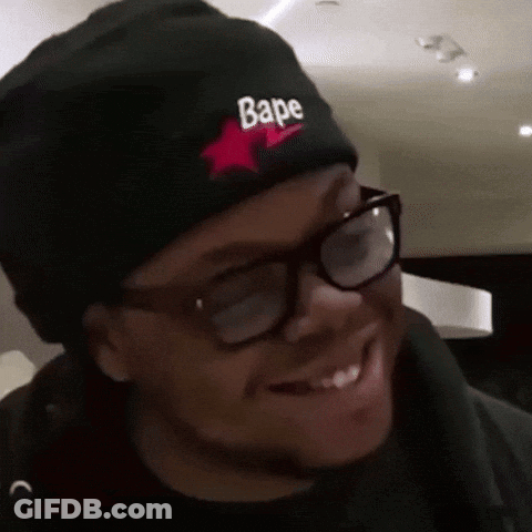 A Man Wearing Glasses And A Black Beanie With The Word Bape On It GIF