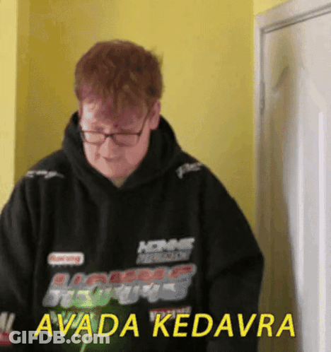 A Man Wearing Glasses And A Black Hoodie That Says Avada Kedavra GIF