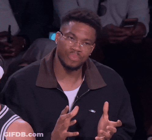 A Man Wearing Glasses And A Black Jacket Has His Hands Up GIF