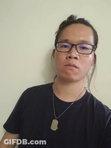 A Man Wearing Glasses And A Black Shirt Has A Dog Tag Necklace Around His Neck GIF