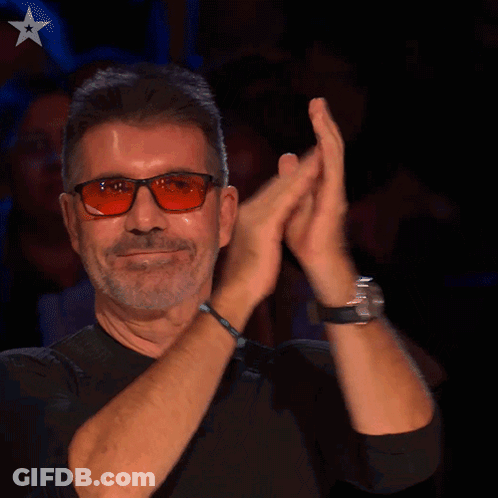 A Man Wearing Glasses And A Black Shirt Is Clapping GIF