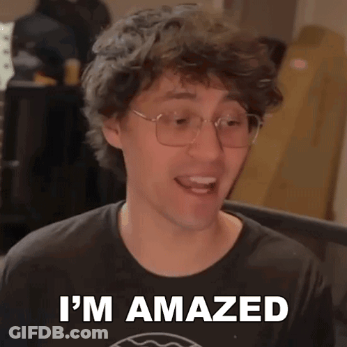 A Man Wearing Glasses And A Black Shirt Is Making A Funny Face And Saying I 'M Amazed . GIF