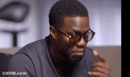 A Man Wearing Glasses And A Black Shirt Looks At The Camera GIF