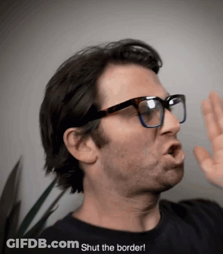 A Man Wearing Glasses And A Black Shirt Says " Shut The Border " GIF