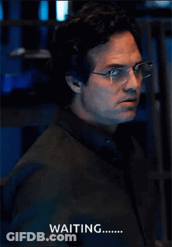 A Man Wearing Glasses And A Black Shirt Says Waiting GIF