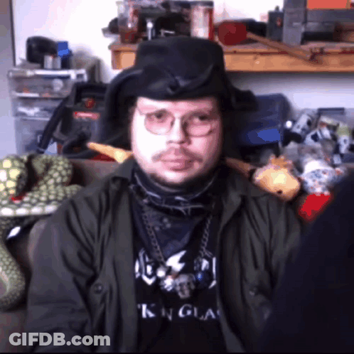 A Man Wearing Glasses And A Black Shirt That Says King On It GIF