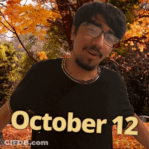 A Man Wearing Glasses And A Black Shirt That Says October 12 On It GIF