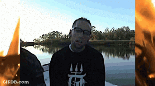 A Man Wearing Glasses And A Black Shirt That Says T On It GIF