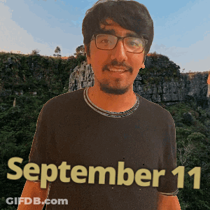 A Man Wearing Glasses And A Black Shirt With The Date September 11 On It GIF