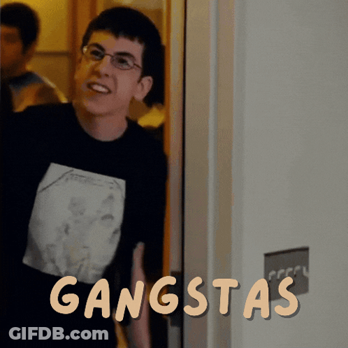 A Man Wearing Glasses And A Black Shirt With The Word Gangsta On It GIF