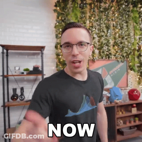 A Man Wearing Glasses And A Black Shirt With The Word Now On It GIF