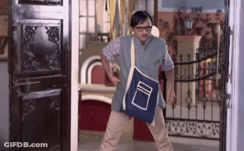 A Man Wearing Glasses And A Blue Bag Is Standing In Front Of A Black Door GIF