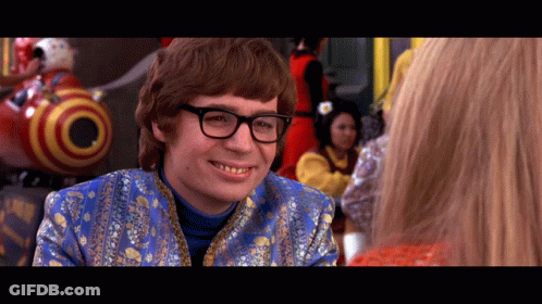 A Man Wearing Glasses And A Blue Jacket Smiles GIF