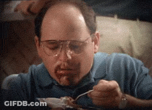 A Man Wearing Glasses And A Blue Shirt Is Eating Food With A Fork . GIF