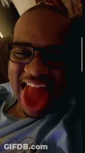 A Man Wearing Glasses And A Blue Shirt Is Making A Face GIF